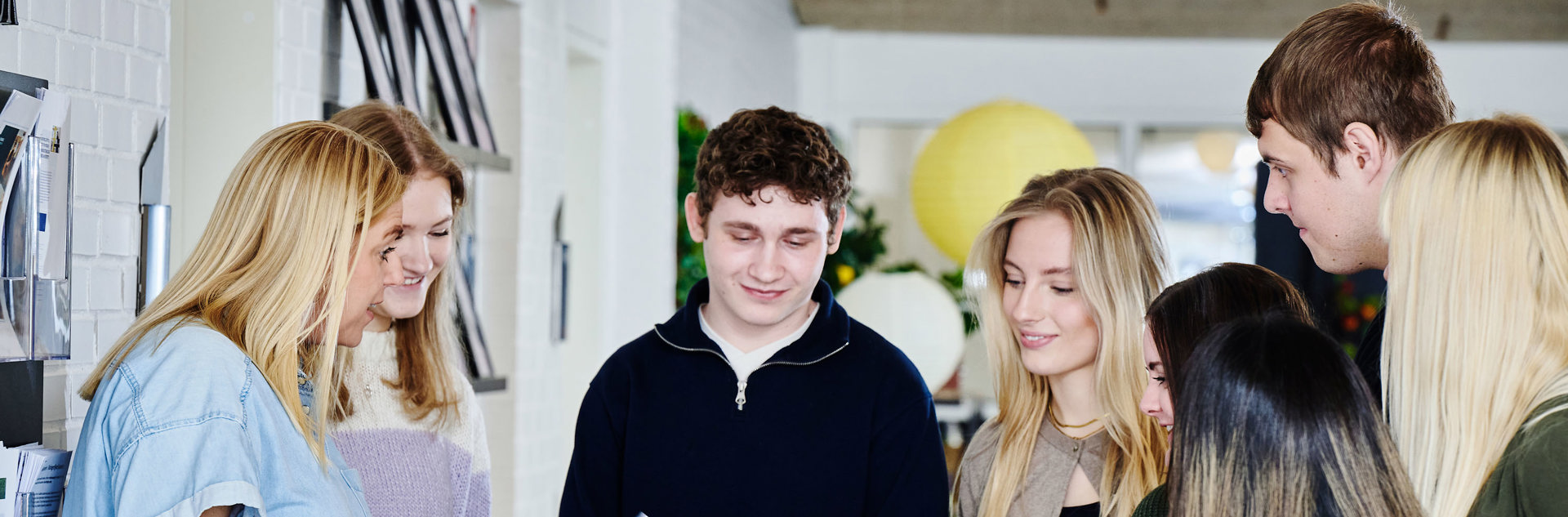 6 elever og en lære står samlet og snakker om en skole opgave